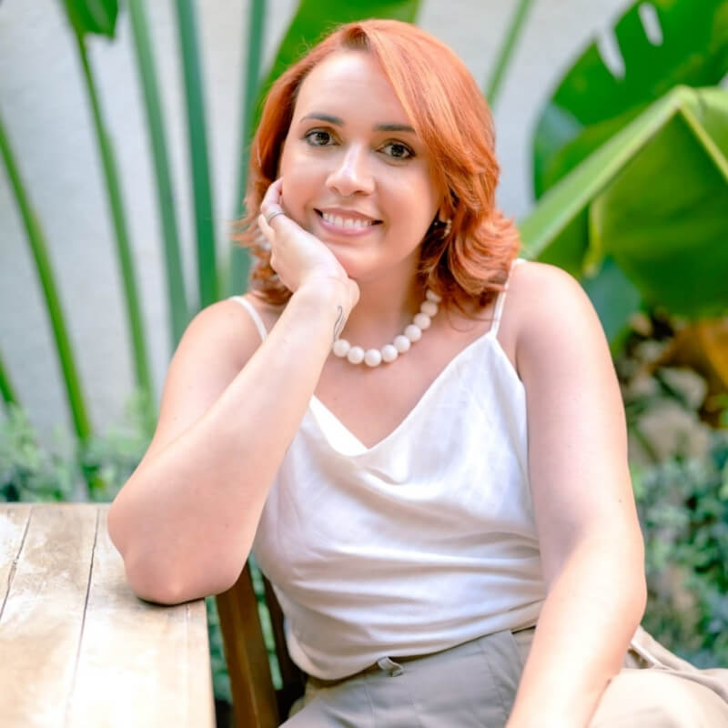 Talita Estrela segurando uma xícara em um ambiente acolhedor